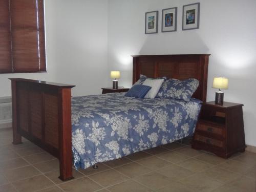 a bedroom with a bed and two night stands with lamps at Sunset Paradise - Ocean View Penthouse Apartment in Cabo Rojo
