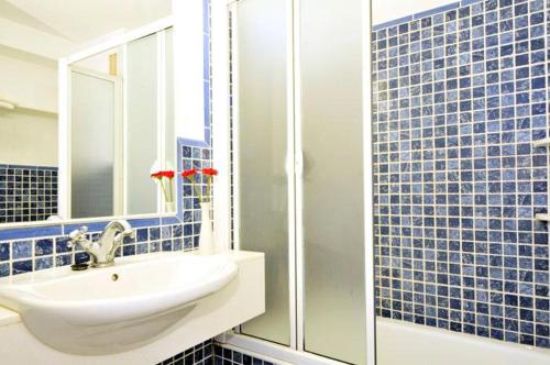 ポルト・ダ・ポリェンサにあるBeachfront apartment Tanamarの青いタイル張りのバスルーム(シンク、シャワー付)