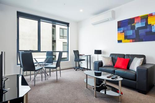a living room with a couch and a table at Melbourne Knox Central Apartment Hotel Official in Wantirna