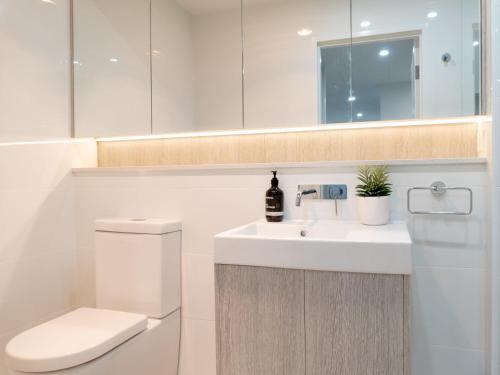 a bathroom with a sink and a toilet and a mirror at Rockpools 1 in Sawtell