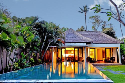 une villa avec piscine devant une maison dans l'établissement Prama Sanur Beach Bali, à anur