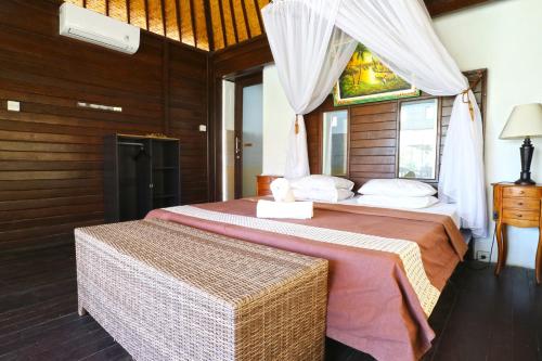 ein Schlafzimmer mit einem großen Bett in einem Zimmer in der Unterkunft Mega Cottages in Nusa Lembongan