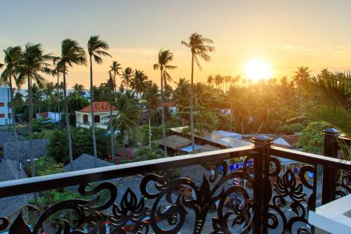 a view from the balcony of a resort with palm trees at PHAM GIA HOTEL Mui Ne in Mui Ne