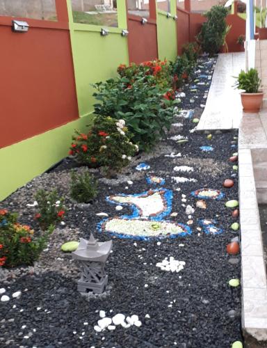 a garden with rocks and flowers on the side of a building at La Casa Binecha avec Jacuzzi in Baillif