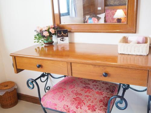 a wooden dressing table with a mirror and a chair at Your Place Inn in Karon Beach