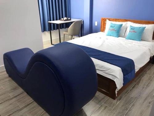 a bedroom with a large bed with blue sheets and a table at Khách sạn Đăng Khoa in Cao Lãnh
