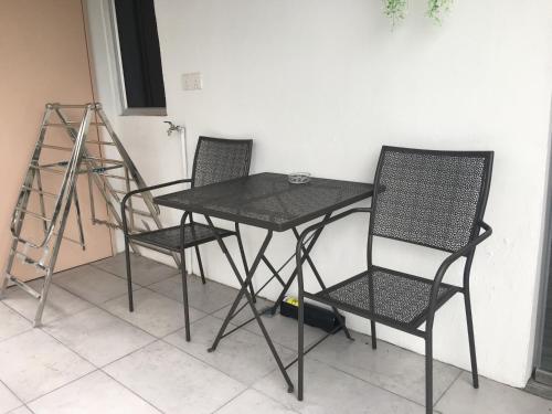 a table and two chairs and a ladder at Signel Hostel in Kota Kinabalu
