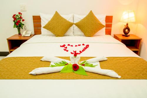 a bedroom with a bed with two towels and hearts at PHAM GIA HOTEL Mui Ne in Mui Ne