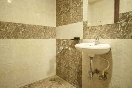 a bathroom with a sink and a mirror at Hotel Sunshine in Mysore