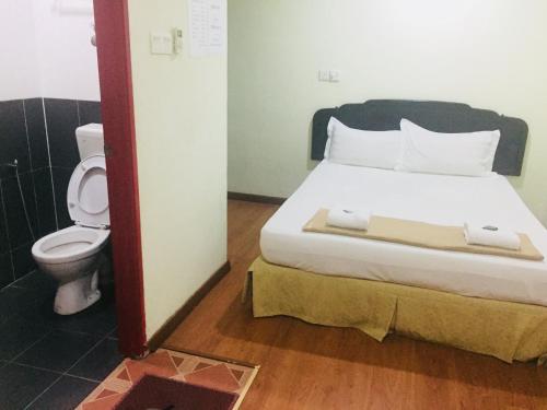 a bedroom with a bed and a toilet in a room at Hotel Sri Malim Sungkai in Sungkai