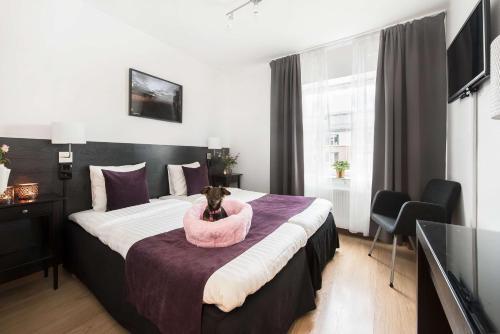 a bedroom with a bed with a dog sitting in a bowl on it at Best Western Hotel City Gavle in Gävle