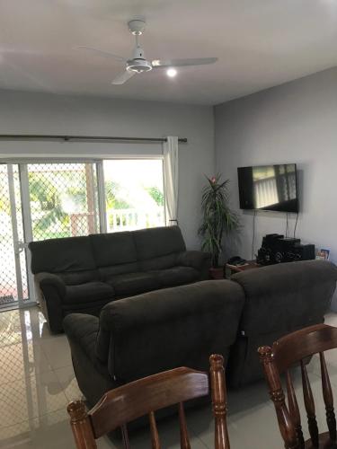 a living room with a couch and a flat screen tv at Inave Holidays in Rarotonga