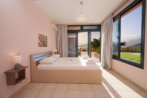a bedroom with a bed and a large window at Fotini in Ayia Evfimia