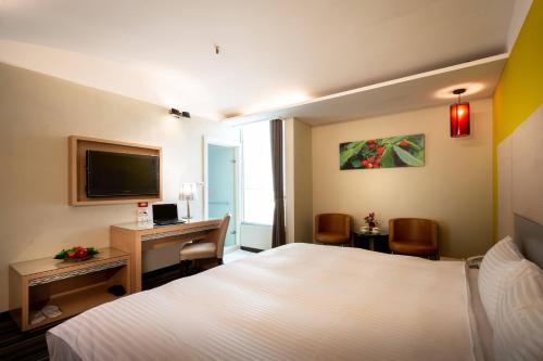 a hotel room with a bed and a desk with a computer at Yoyo Hotel in Chiayi City