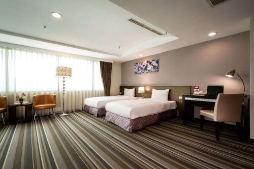 嘉義市的住宿－嘉義優遊商旅，酒店客房配有两张床和一张书桌