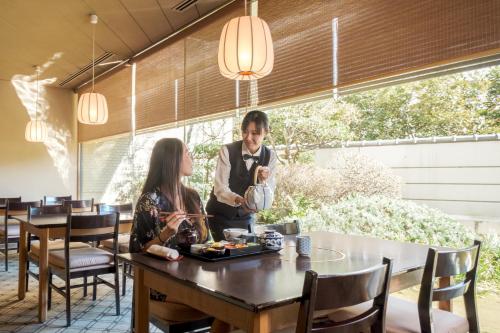 a man and woman sitting at a table in a restaurant at Hotel Okura Tokyo Bay in Tokyo