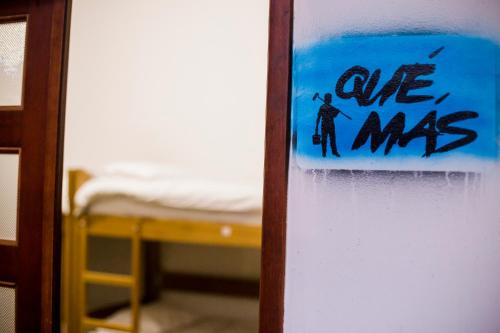 a sign on a door in a room with a bed at Fatima Hostel Bogotá in Bogotá