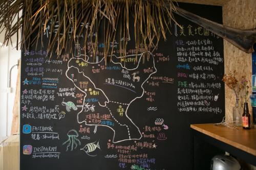 a chalkboard with writing on a wall in a restaurant at Slow Island Hostel in Green Island