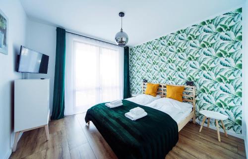 a bedroom with a large green leafy wall at Apartamenty Sun Seasons 24 - Żeromskiego in Szklarska Poręba