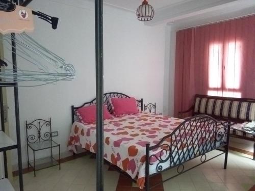 a bedroom with a bed with pink pillows at immeuble selma 3 in Hammamet