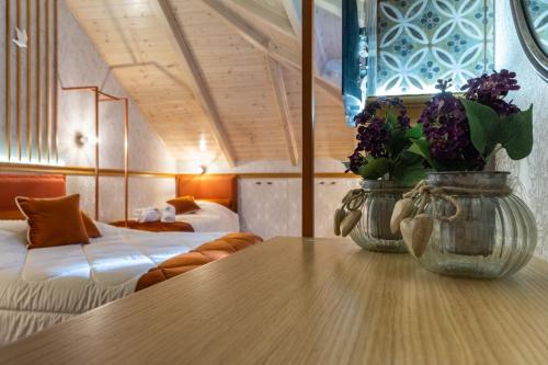 a room with a table with a vase of flowers on it at Villa Virginia Hotel in Karpenision