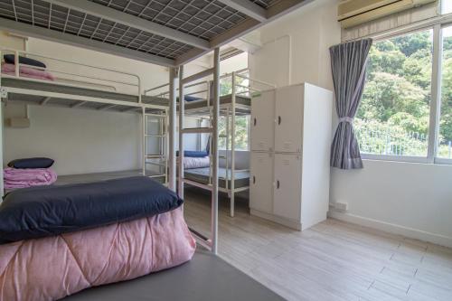 a dorm room with bunk beds and a window at YHA Jockey Club Mt. Davis Youth Hostel in Hong Kong