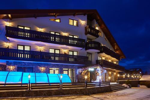 a large white building at night with lights at Graal resort in Bukovel