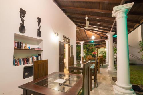 a dining room with a table and columns at Green Villa Unawatuna in Unawatuna