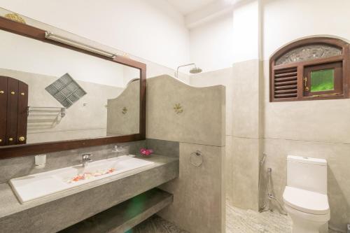 y baño con lavabo, aseo y espejo. en Green Villa Unawatuna en Unawatuna