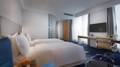 Ένα ή περισσότερα κρεβάτια σε δωμάτιο στο Holiday Inn Express - Qingdao West Coast by IHG