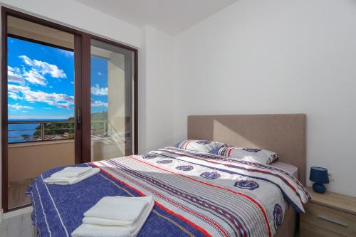 a bedroom with a bed with a view of the ocean at Apartment Sidro in Petrovac na Moru