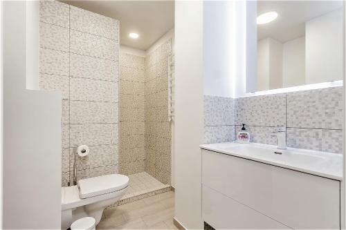 a white bathroom with a toilet and a sink at Apartments Vilnius 1 near center with a roof terrace and parking in Vilnius