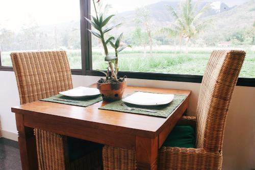 a wooden table with two chairs and a plant on it at d'Sawah Amed Homestay & Warung in Amed