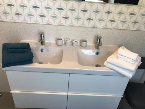 a bathroom sink with two sinks and two towels at La chouette au bouleau in Hargnies