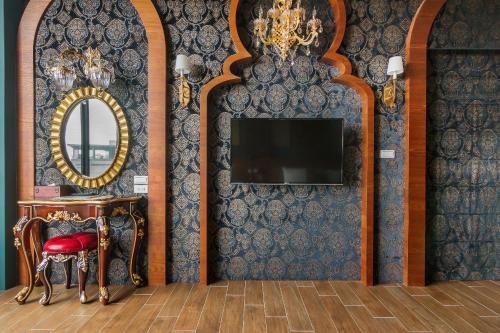 a room with a mirror and a tv on a wall at The Dawn B&B in Jian