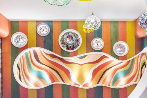 a dining room with colorful stripes and plates on the wall at The Dawn B&B in Jian