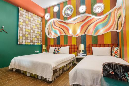 two beds in a room with clocks on the wall at The Dawn B&B in Jian