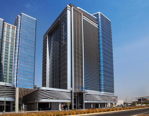 a tall building with many windows on a street at Centro Capital Centre By Rotana in Abu Dhabi