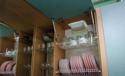 a pantry with glasses and dishes on shelves at Babylon Apartments in Rivne