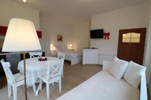 a living room with a white couch and a table at Villa SORENTO in Mielno