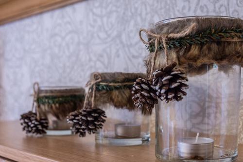 a glass jar with pinecones and candles on a table at Villa Virginia Hotel in Karpenision