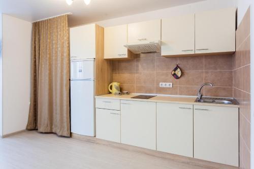 キーウにあるSuper new apartment near airport Zhulyany(Kiev)の白いキャビネットとシンク付きのキッチン