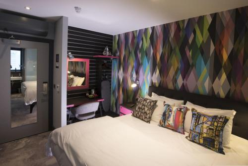 a bedroom with a bed and a colorful wall at Village Hotel Bristol Filton in Bristol