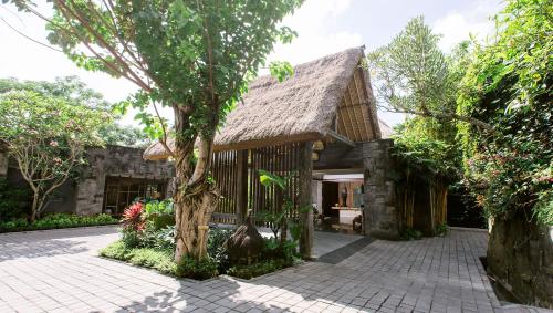 a large stone building with a tree in front of it at Tejaprana Resort & Spa - CHSE Certified in Ubud