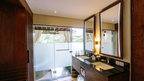 baño con 2 lavabos y espejo grande en Tejaprana Resort & Spa en Ubud