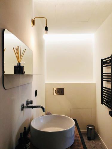 La salle de bains est pourvue d'un lavabo blanc et d'un miroir. dans l'établissement Casa Marghera 24, à Milan