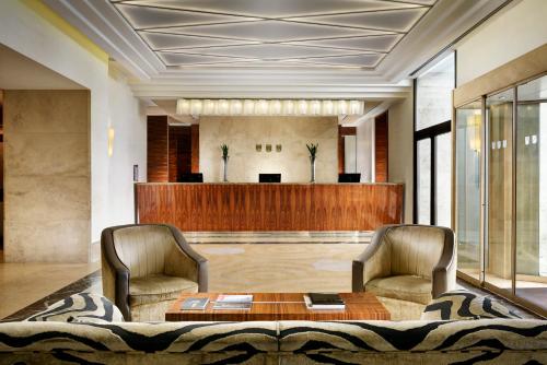 a lobby with two chairs and a waiting room at UNAHOTELS Decò Roma in Rome