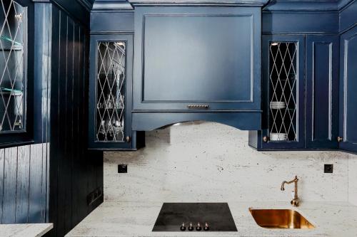 - une cuisine avec des placards bleus et un évier dans l'établissement Apartament Indygo, à Łomża