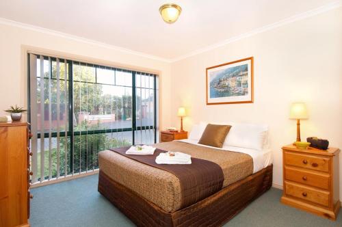 En eller flere senge i et værelse på Mount Waverley Townhouses