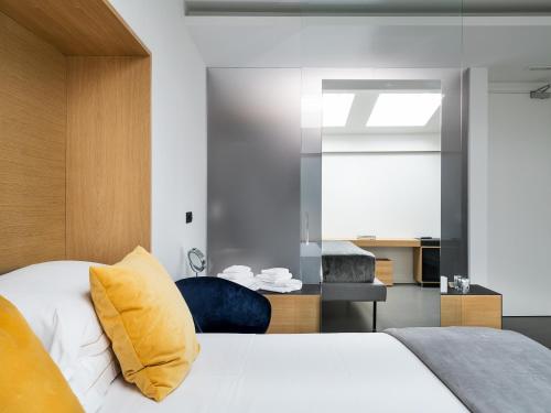 a bedroom with a white bed and a yellow pillow at Habitat Boutique Hotel in Catania